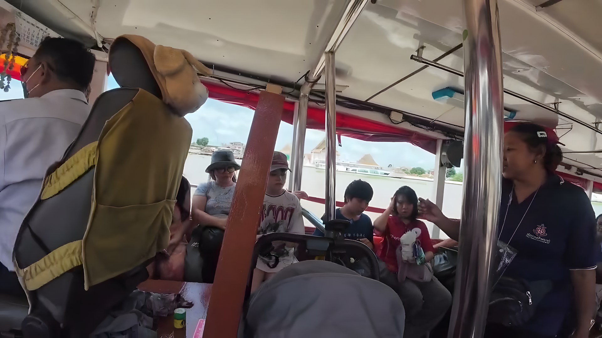 Chao Phraya Nehri toplu teknesinin içi, yolcular ve nehir manzarası