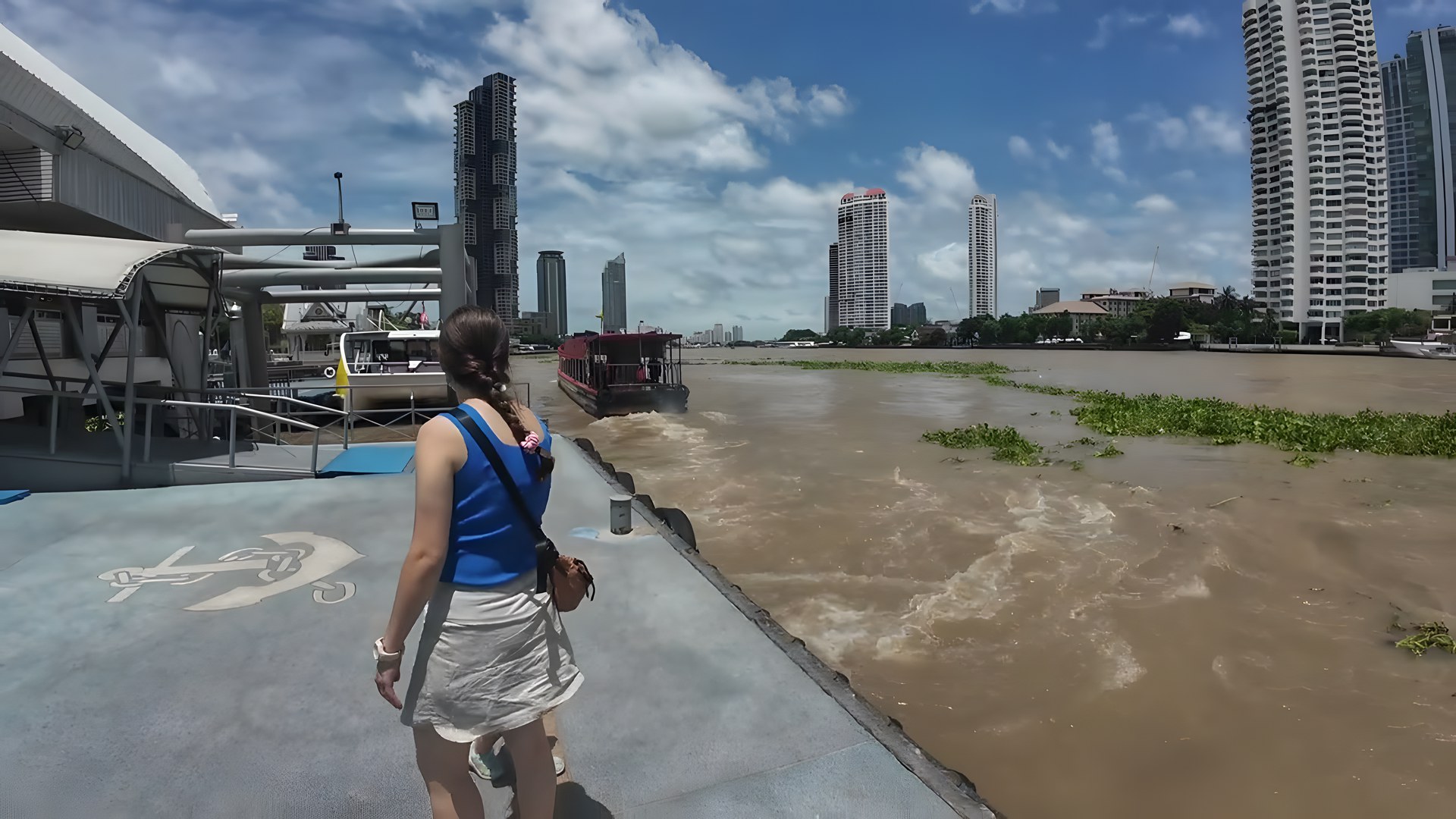 Sathorn iskelesi yürüyüş yolu, Chao Phraya üzerindeki tekne ve Bangkok gökdelenleri