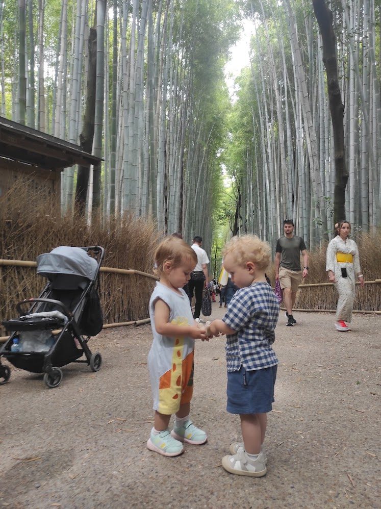 Arashiyama bambu ormanında iki çocuk el tutuşuyor - Kyoto