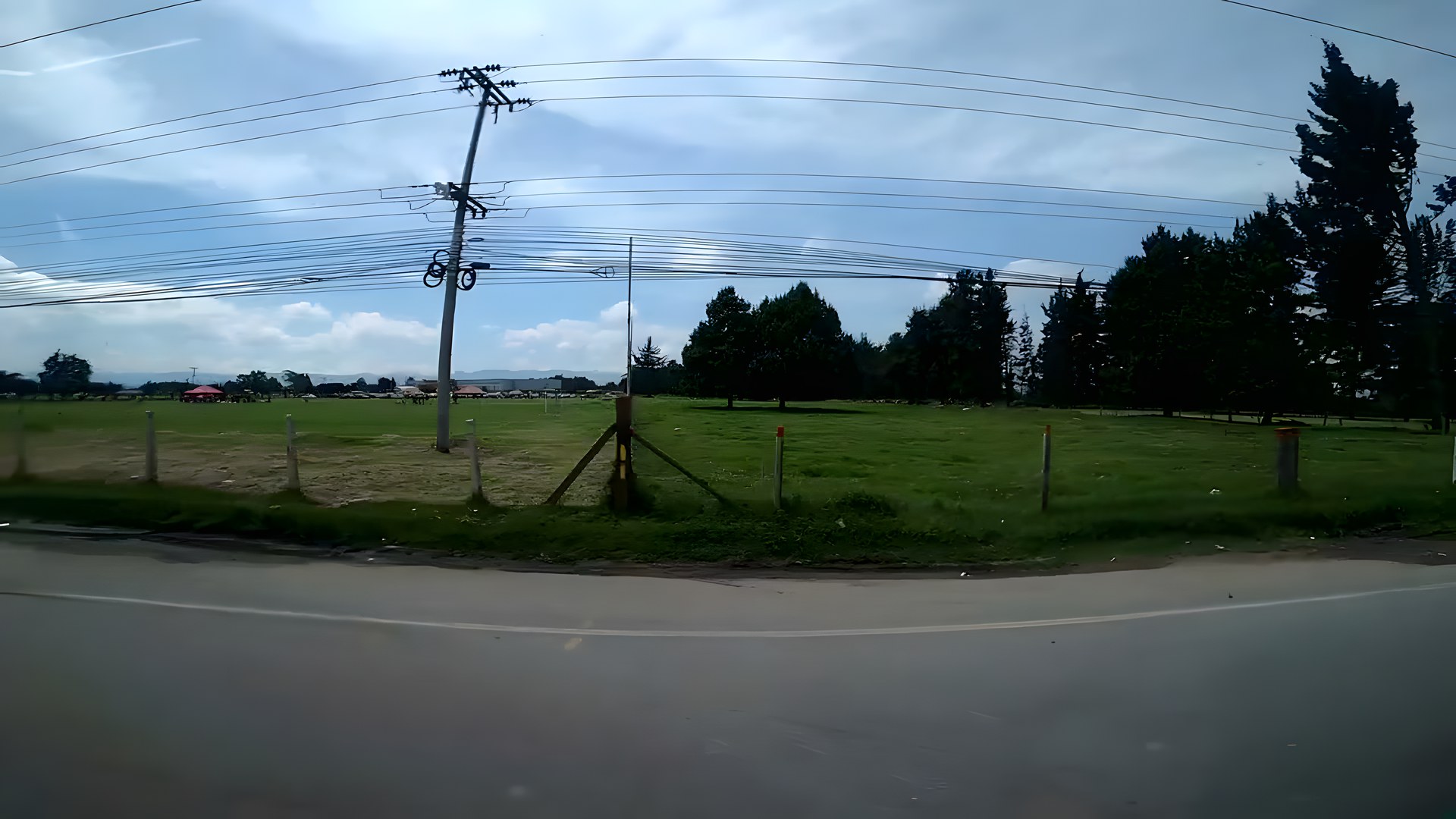 Bogotá'da ağaçlarla çevrili yeşil promenad ve arkada And Dağları