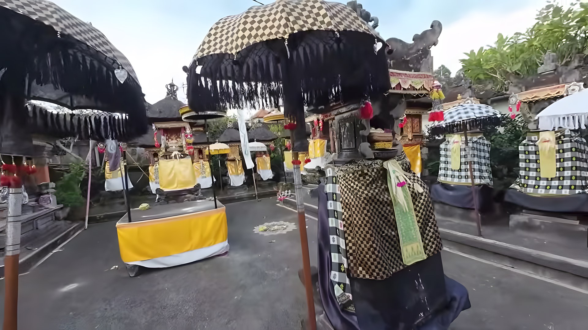 Galungan festivali için tören şemsiyeleri ve sunularla süslenmiş Bali aile tapınakları