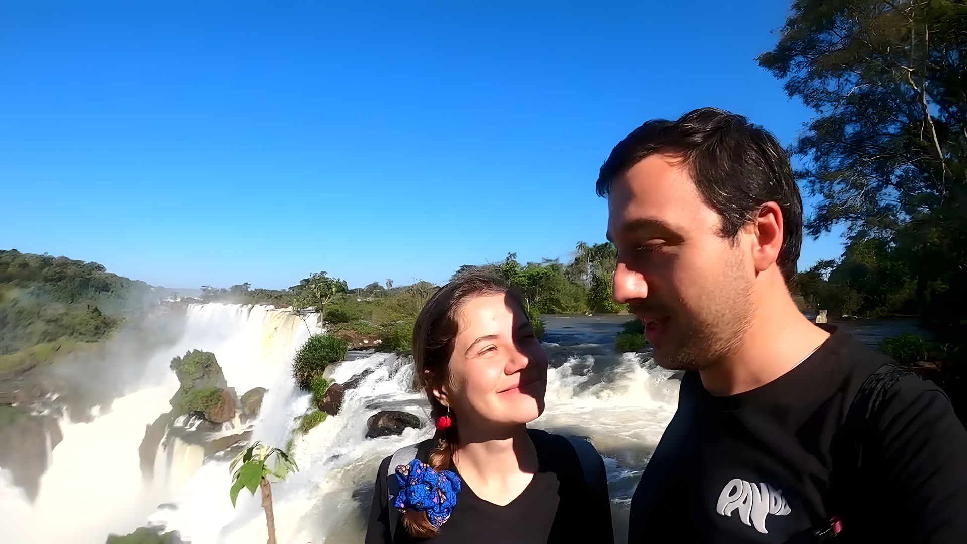 Iguazu Şelaleleri önünde gökkuşağı eşliğinde aile fotoğrafı